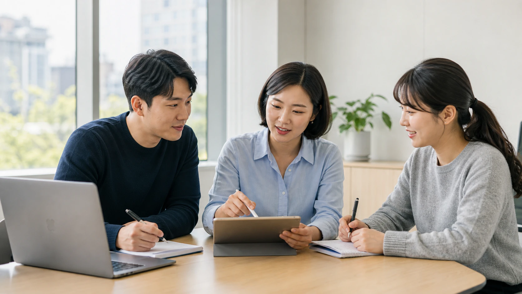 밝은 회의실에서 태블릿을 보며 다음 업무를 논의하는 세 명의 제품팀 구성원